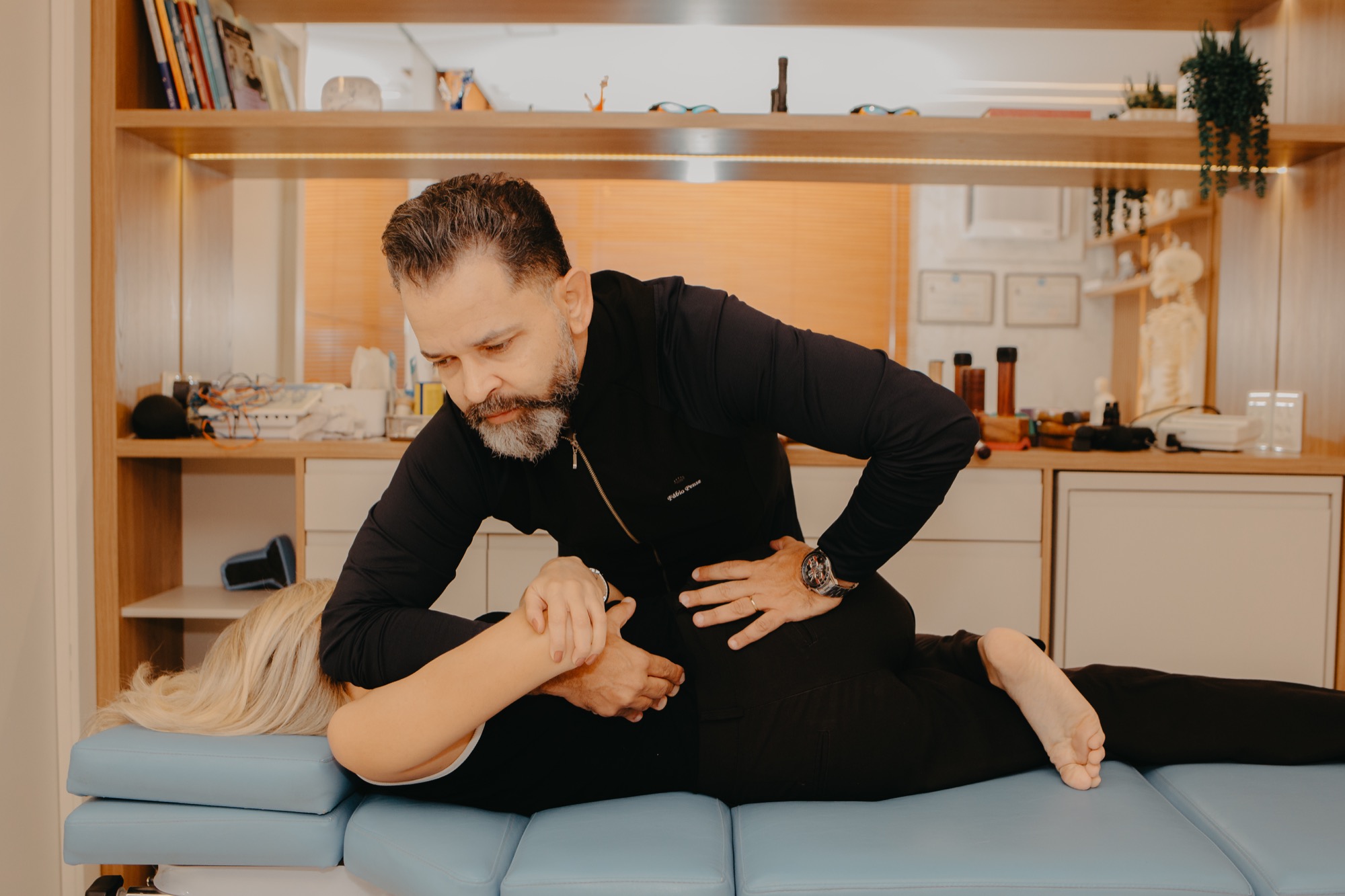 Fábio Pense avaliando a coluna de uma paciente antes de um atendimento na Clínica Fábio Pense, em Lourdes, Belo Horizonte